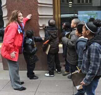 Photo of a group of children touching a building