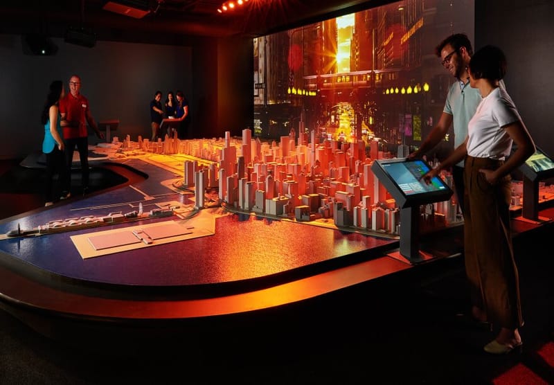 two people in from of the city model with red lighting