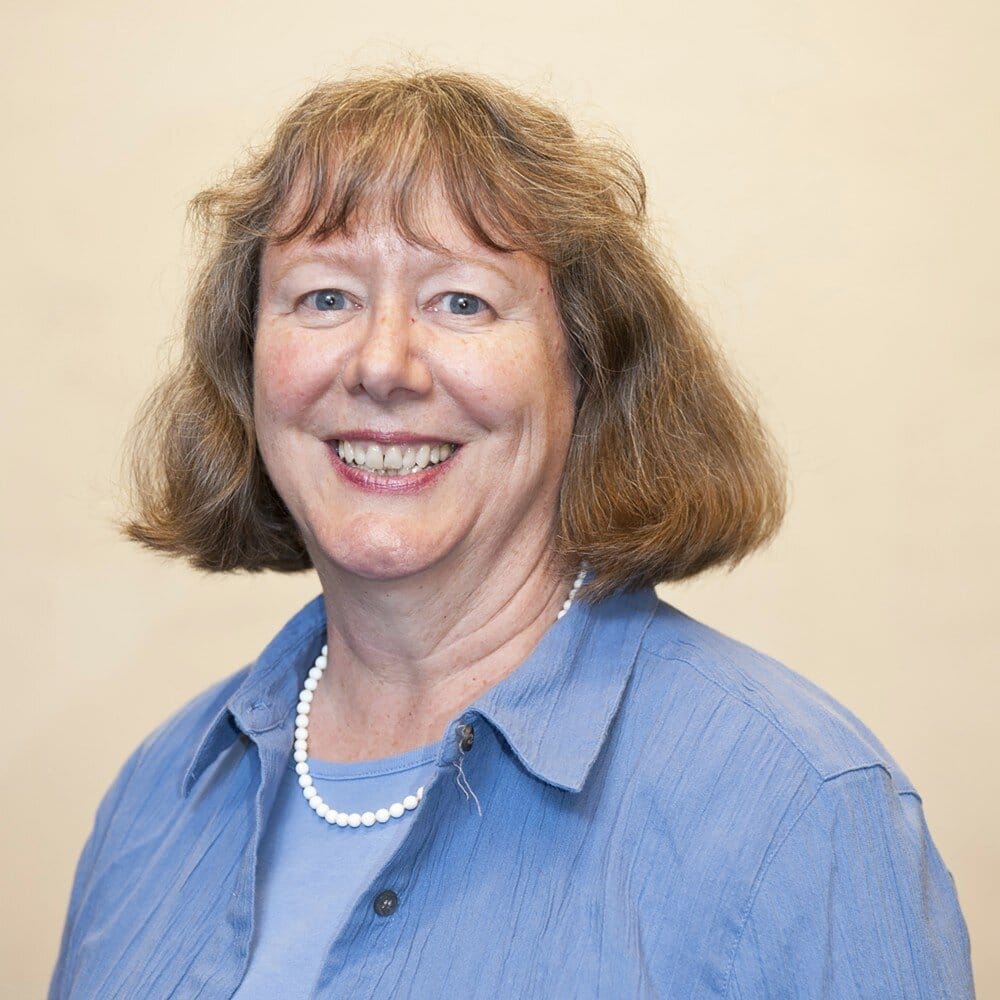 Caucasian lady with shoulder length hair in a blue shirt