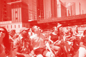 People on a boat looking up at buildings