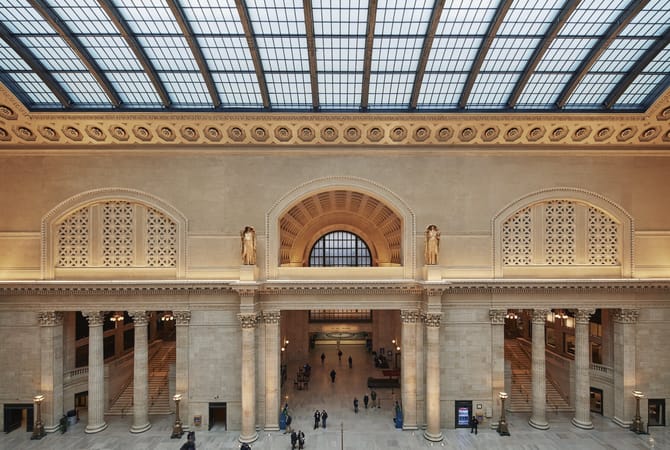 Interior image of a large building with tan walls and large columns.